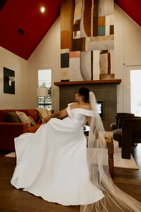 Bride with cathedral veil by the living room fireplace