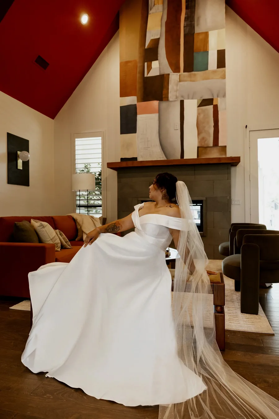 Bride in a cathedral veil beside the fireplace in the living room of The Penrose House luxury wedding estate