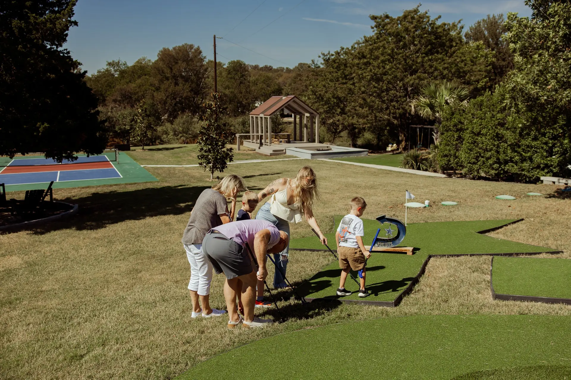 Guests playing mini-golf on the outdoor course at The Penrose House