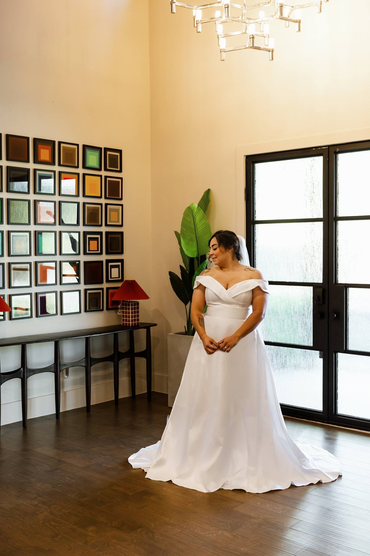 Bride by the tall entry windows and art wall, The Penrose House