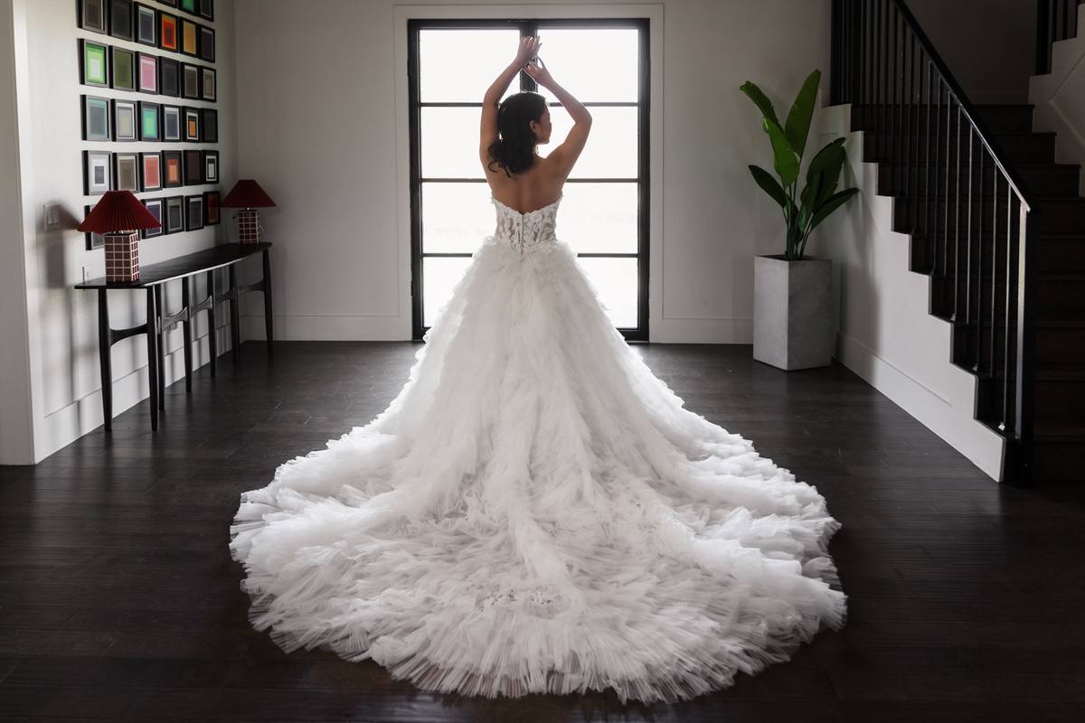 Bride with a full ball-gown train in the entryway by the staircase, The Penrose House