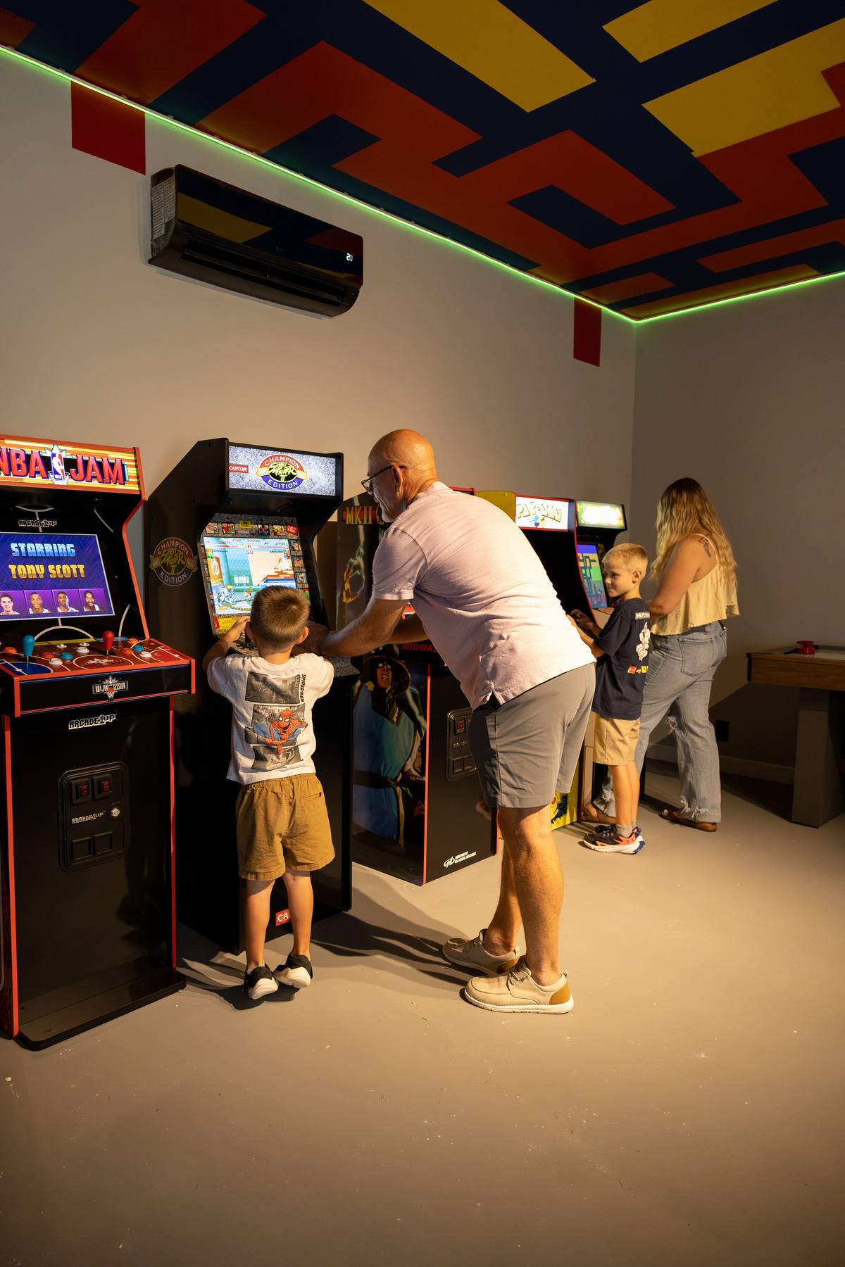 Family playing arcade games together, The Penrose House