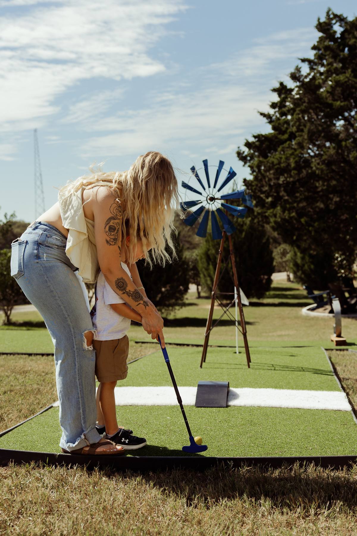 Mom teaching a child to putt on the mini-golf course, The Penrose House