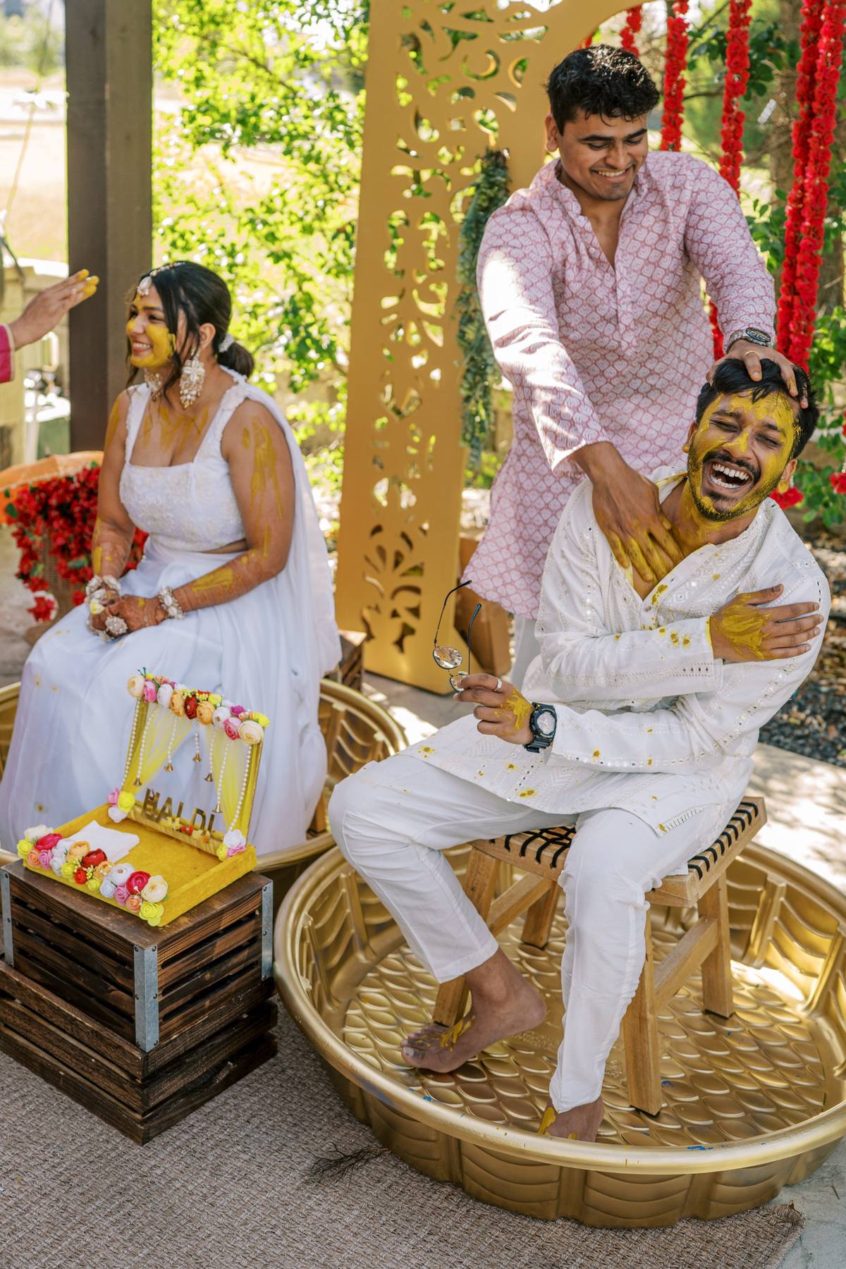Groom laughing during the haldi ceremony on the covered patio, The Penrose House