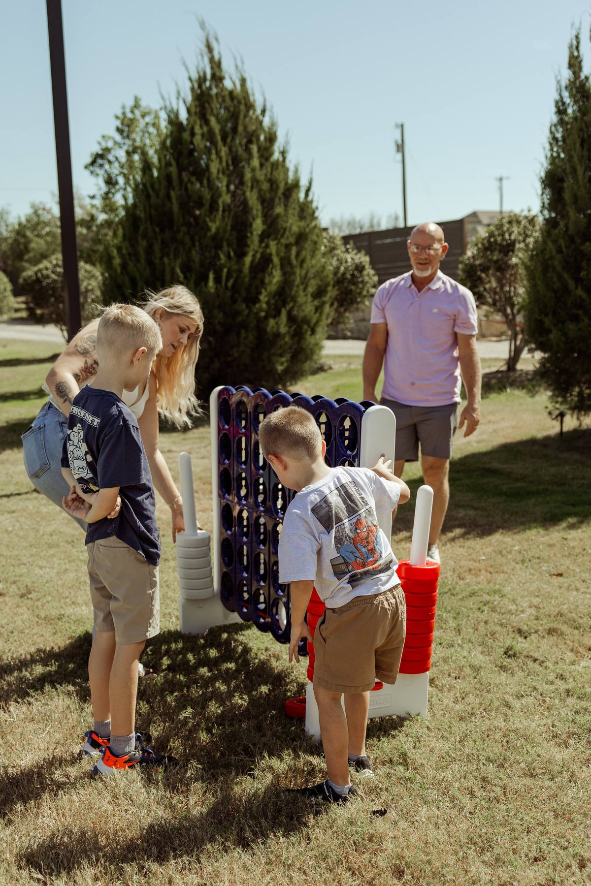 Family playing giant Connect Four on the lawn, The Penrose House