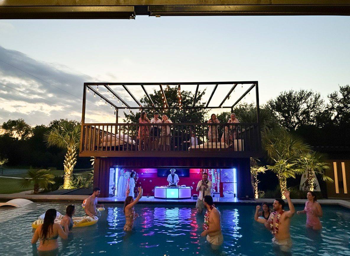 Swim-up bar lit at night with guests in the pool, The Penrose House