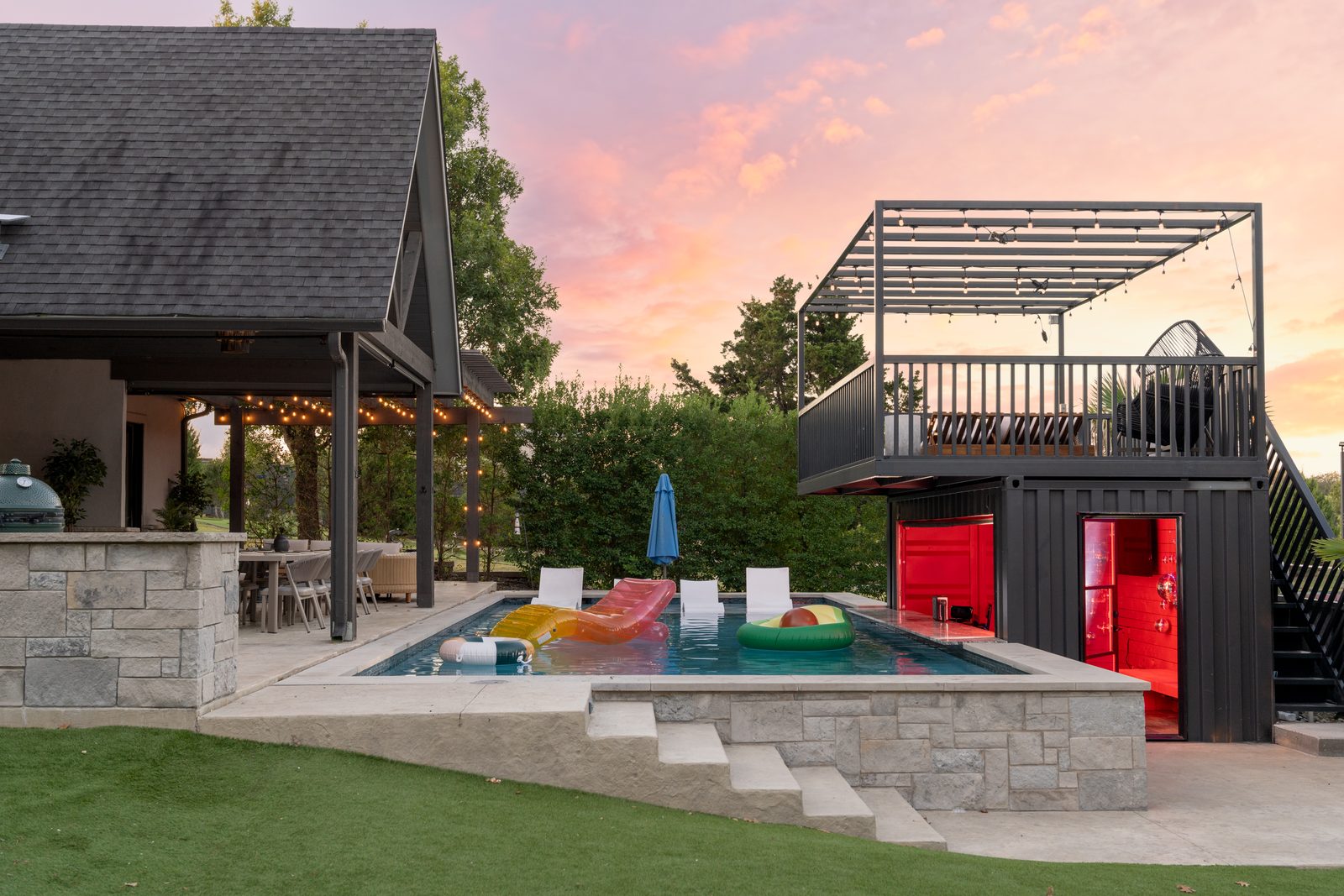 Full pool area at sunset with stone pool, floats, A-frame container at The Penrose House